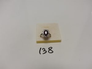 1 bague en or et platine centrée d'une pierre rouge sang (chocs sur les bords) entourage petits diamants et 1 pierre (Td55). PB 6,7g