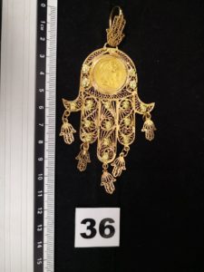 1 Pendentif en or, main de fatma sertie d'une pièce de 20Francs Napoléon III. PB 26,5g