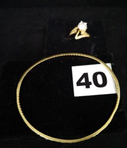 1 Bracelet artisanal rigide tordu ovale et 1 bague orné de pierres blanches (TD 53). Le tout en or. PB 11,5g