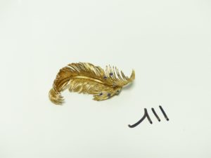 1 Broche en or à décor d'une plume ornée de pierres bleues (abimée). PB 20,1g