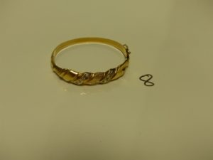 1 Bracelet en or rigide et ouvrant motif central orné de 2 rangs de pierres (Diamètre 5,5/6cm). PB 16,7g