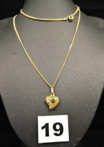 1 Chaine maille anglaise (L 60cm) et 1 pendentif ajouré motif coeur réhaussé d'une pierre verte élimée. Le tout en or. PB 6,9g