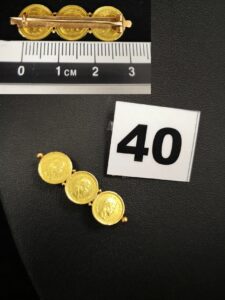 1 Broche en or ornée de 3 pièces de 4 Pesos soudées entre elles. PB 4g