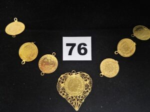 1 Motif pièce en pendentif, dans un entourage filigrané et 6 motifs pièces certains avec attaches tordues. Le tout en or. PB 11,7g