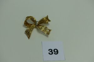 1 broche en or à décor d'un noeud orné de petits diamants. PB 18,9g