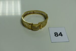 1 bracelet rigide articulé ouvrant en or motifs central orné de petites pierres (1 chaton vide,diamètre 5,5/6cm). PB 19,1g