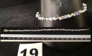 1 Bracelet en alliage gris 585/1000 (14K L18cm, articulé) orné de pierres mauves. PB 5,7g