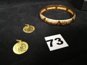 2 Pendentifs avec motif pièce de 10Fr et 1 Bracelet rigide (diam 6,2cm). Le tout en or. PB 18,1g