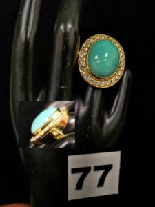 1 Bague en or ornée d'un imposant cabochon turquoise dans un entourage de diamants (TD 51). PB : 14,2g