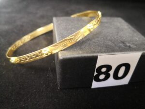 1 Bracelet en or rigide ajouré bicolore à petites fleurs en relief ( cabossé diam 6,4cm). PB 7,5g