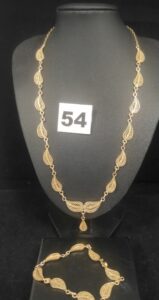 1 Bracelet articulé de motifs gouttes filigranés (L 17,5cm) et 1 collier assorti (L 45cm). Le tout en or. PB 24,6g