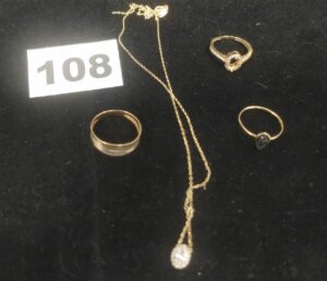 1 Bague striée (TD57), 1 bague motif goutte, 1 collier cassé avec pierre centrale et 1 bague avec petites pierres (chatons vide). Le tout en or. PB 6,9g