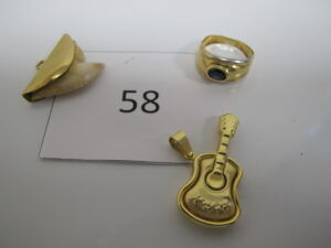 1 Pendentif en or à décor d'une guitare 1 bague en or ornée d'une pierre bleue (TD52),1 pendentif en or rehaussée d'une dent.PB10,69g