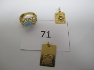 1 Bague en or ajourée et rehaussée d'une pierre bleue(TD55),1 pendentif en or plaque astrologique du signe du scorpion,1 pendentif en or à décor de livre gravé "+ qu'hier et - que demain".PB 9,9g.