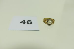 1 Bague en or réhaussée d'une perle blanche épaulée de 2 petites pierres (Td 52). PB 3G