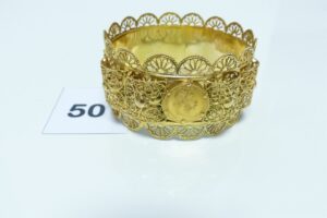 1 bracelet esclave à motif filigrané en or 750/1000 et serti de 4 pièces d'un florin (diamaètre 6,5cm). PB 69,8g