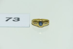 1 bague en or 750/1000 centrée d'une pierre bleue épaulée de 6 petits diamants (Td54). PB 3,4g