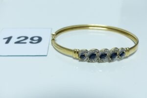 1 bracelet rigide ouvrant en or 750/1000, motif central bicolore et orné de 5 petits saphirs et 10 petits diamants (diamètre 4,5/5,5cm). PB 8,6g