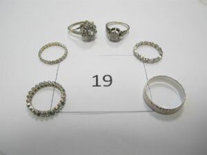 1 Alliance en or gris 18k(750/1000) pierres vertes et diamants(TD52),1 alliance ciselée en or 18k(750/1000) (TD62),1 bague en or gris(TD51)pavée de pierres blanches,1 bague en or gris (750/1000)(TD54)pavée de pierres,1 alliance en or gris 18k(750/1000)et petits diamants(TD49),1 alliance en or gris et petits diamants(TD51).PB 17,98g.