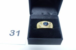 1 Bague ornée d'une pierre bleue épaulée de 6 petits diamants (Td66) en or 750/1000. PB 9,9g