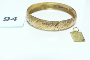1 Bracelet rigide et ouvragé (cabossé, Diamètre 7cm) et 1 pendentif signe du scorpion. Le tout en or 750/1000. PB 19g