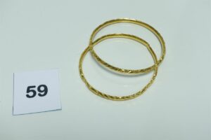 2 bracelets rigides et ouvragés en or 750/1000 (1 cabossé, diamètre 7cm). PB 23,7g