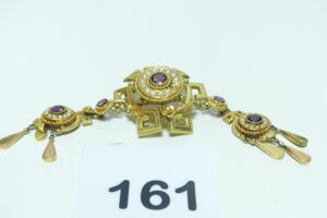 1 broche ancienne en or 750/1000 ornée de petites pierres violettes (2 chatons vides) et de perles, 2 motifs en pampille (restaurée, manque 1 perle). PB 18,5g