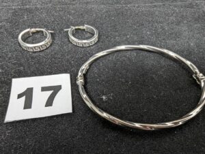 2 Boucles, petites creoles en or gris ciselées (Diam 1,8cm) et 1 bracelet torsadé rigide ouvrant en or gris. Le tout en 750/1000 18k. PB 6,6g