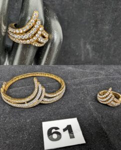 1 Bracelet rigide ouvrant motif en "V" pavé de pierres, et 1 bague en "V" pavée de pierres (TD50). Le tout en or 750/1000 18k. PB 23,7g