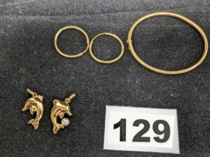 1 Bracelet rigide ouvrant pour enfant (Diam 4,5cm), 2 petites créoles (Diam 2cm), 2 pendentifs dauphins dont 1 avec perle. Le tout en or 750/1000 18k. PB 5,5g