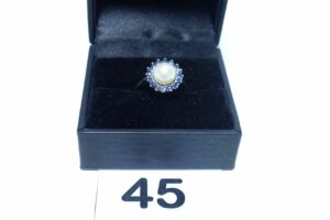 1 Bague en or 750/1000 rehaussée d'une perle entourage petites pierres bleues (td53). PB 2,9g