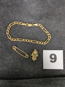 1 Bracelet maille alternée (L15cm), 1 épingle et 1 main de fatma en pendentif.Le tout en or 750/1000 18k. PB 6,7g