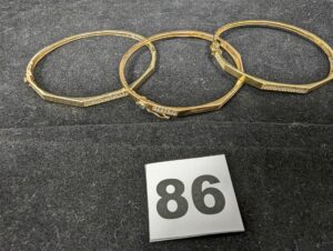 3 Bracelets facetés rigides ouvrants ornés de pierres. Le tout en or 750/1000 18k. PB 19g