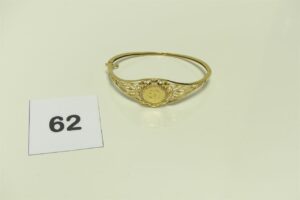 1 Bracelet rigide et ouvrant en or 750/1000 motif central orné de pierres (Diamètre 7cm, abimé). PB 9,9g