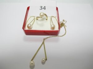 1 Bague en or 18k(750/1000)rehaussée d'une perle blanche entourée de petites pierres blanches(TD55),2 pendants en or 18k(750/1000)rehaussés de perles blanches,1 collier en or 18k(750/1000). rehaussé de 2 perles blanches(L24cm) fermoir absent.PB 7,73 g.