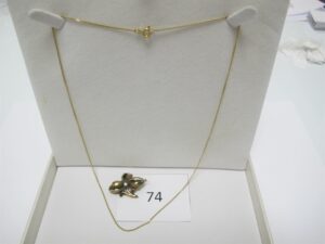 1 Chaine en or 18k(750/1000)(L45cm),1 broche ancienne en or 18k(750/1000) représentant 1 fleur rehaussée d'une perle(1 pétale fragilisée).Pb 3,90g.