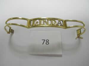 1 Bracelet en or 18k(750/1000)ouvrant gravé"Linda"dt 1 lettre en or gris(6cm).PB 26,2g.