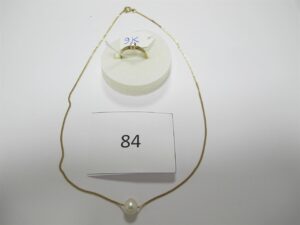 1 Collier en or 18k(750/1000)composé d'une chaine fine rehaussée d'1 perle blanche(L40cm),1 bague solitaire en alliage 9k(375/1000)(TD53)rehaussé d'un petit diamant.PBT or 18 k(750/1000) et alliage 9k(375/1000)4,44 g ( or 18k 750/1000) et perle 3,20 g // alliage 9 k (375/1000)1,25g.