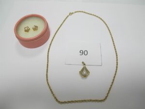 1 Chaine en or 18k(750/1000)maille torsadée(L44cm),1 pendentif en or 18k (750/1000)rehaussé d'une perle,2 bouclesd'oreilles or 18k(750/1000)rehaussées deperles manque les 2 accroches.PB 10,4g.