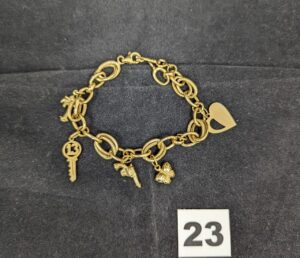 1 Bracelet en maille alternée réhaussé de breloques diverses (L20cm) en or 750/1000 18k. PB 14,4g