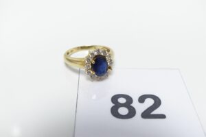 1 Bague en or 750/1000 ornée d'une pierre bleue entourée de 11 petits diamants (1 chaton vide, Td57). PB 5,1g