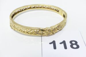 1 Bracelet rigide ouvrant en or 750/1000 motif central orné de petites pierres (petits chocs, diamètre 5/6cm). PB 16,4g