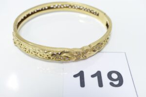 1 Bracelet rigide ouvrant en or 750/1000 motif central orné de petites pierres (diamètre 5,5/6,5cm). PB 16,6g