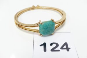 1 Bracelet rigide ouvrant en or 750/1000 serti-griffes une pierre verte cabochon (vr Amazonite)(diamétre 5/5,5cm) avec chaînette de sécurité. PB 21,8g