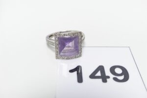 1 Bague en or 750/1000 centrée d'une pierre violette entourée et épaulée de petits diamants (Td55). PB 4,5g