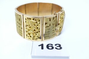 1 Bracelet large en or 833/1000 (20K) maille articulée et à décor asiatique (L18cm) avec chaînette de sécurité. PB 94g