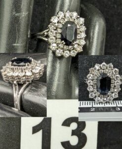 1 Bague type pompadour ornée d'une pierre bleue sombre doublement cerclée de petits diamants (TD53), en or gris 750/1000 18k. PB 6,3g