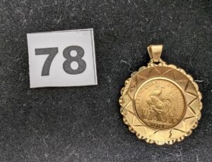 1 Médaille Marianne de 20fr 1914, sertie griffe dans un entourage ouvragé, en or 916 et 750/1000 22k et 18k. PB 9,6g
