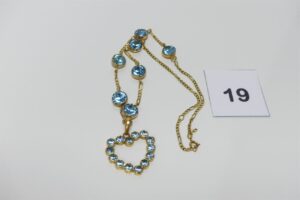 1 collier en or orné 750/1000 orné de 7 grosses pierres bleues et d'un motif central à décor d'un coeur orné de pierres (L47cm). PB 24,7g