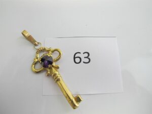 1 Pendentif en or 18k(750/1000)motif clé rehaussée d'une pierre violette. PB 2,86g.